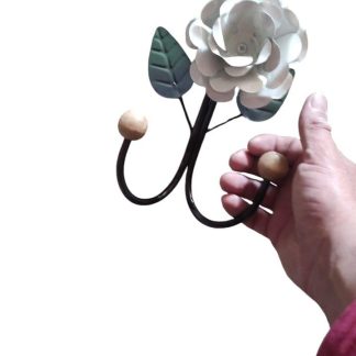 Cabide rústico de ferro com flor em madeira maciça, medindo 26 cm.