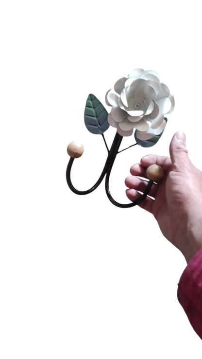 Cabide rústico de ferro com flor em madeira maciça, medindo 26 cm.